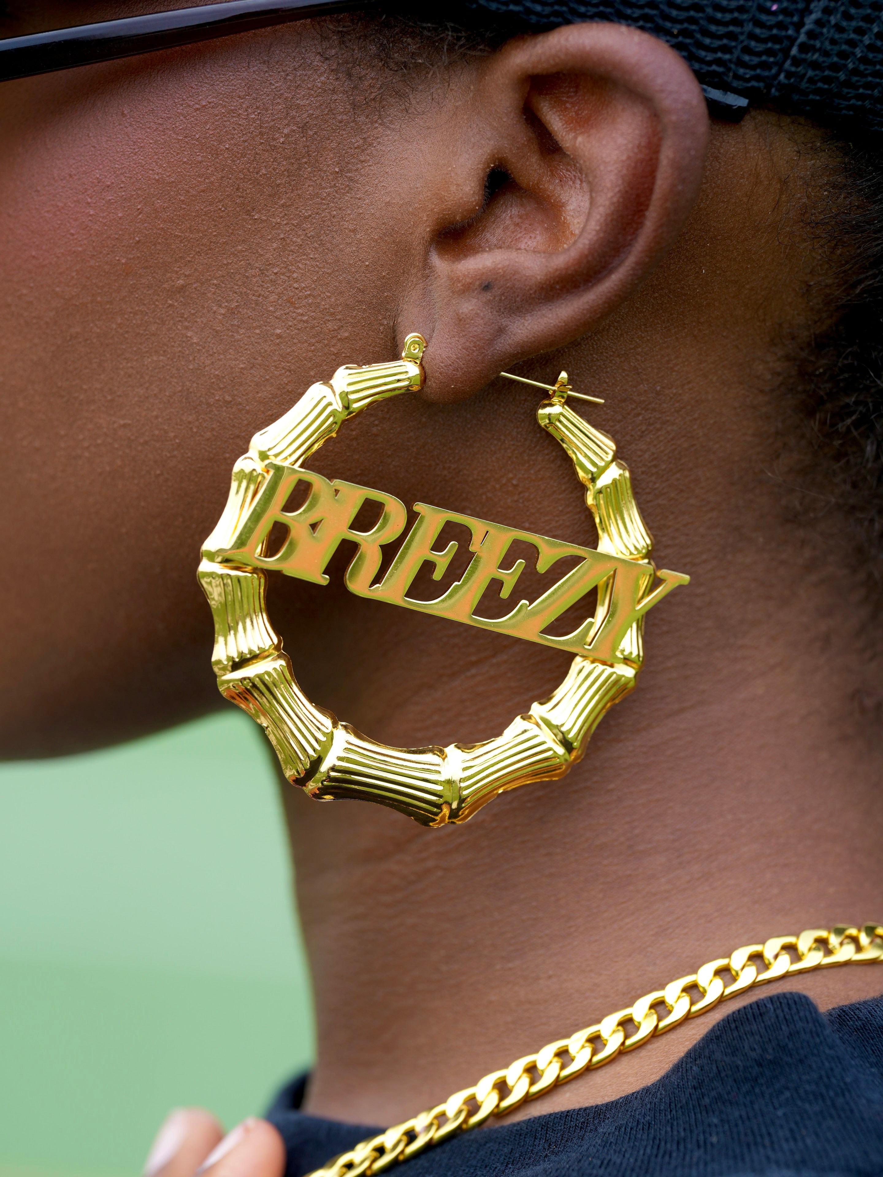 Image of Close-up of woman wearing gold Breezy bamboo hoop earrings and chain necklace