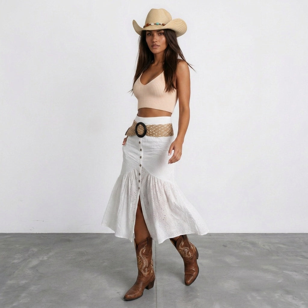 Image of Full body view of a coastal cowgirl hat paired with a white skirt and brown boots, boho western style