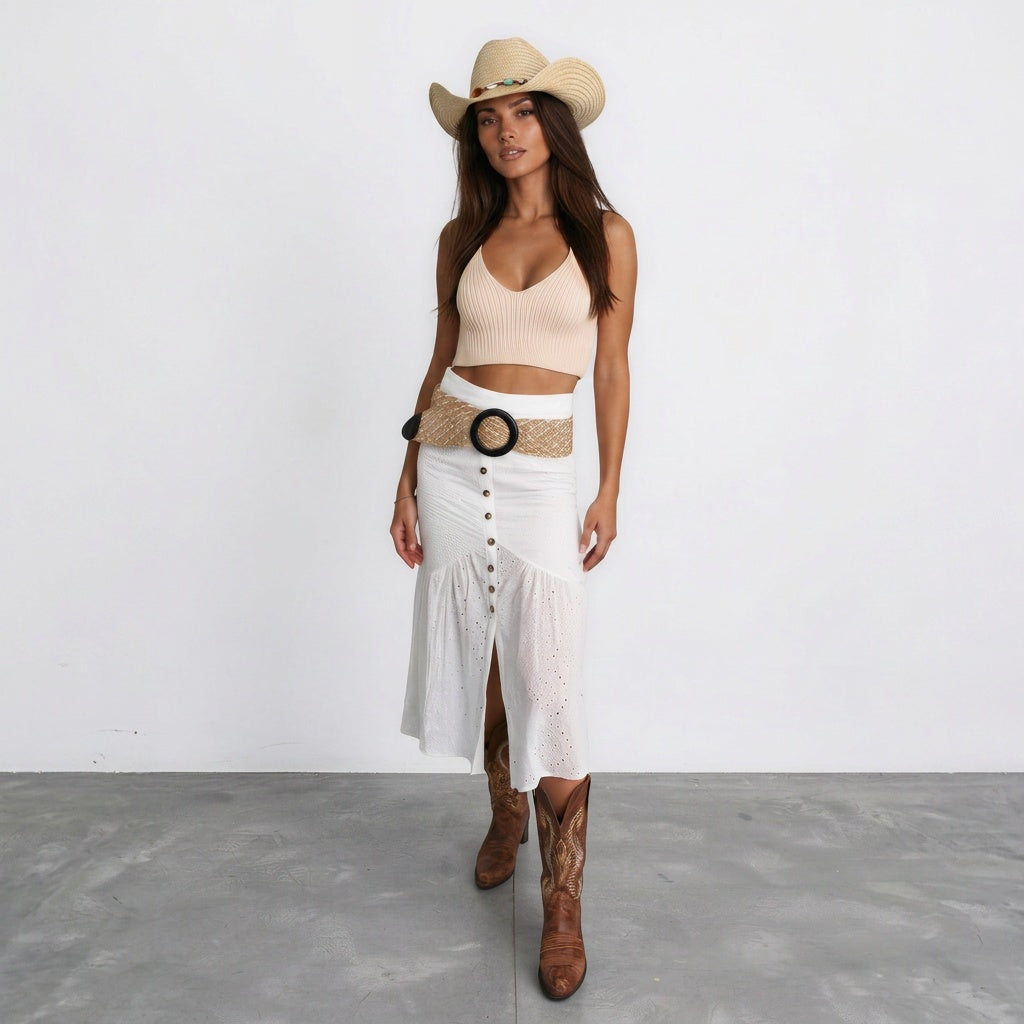 Image of Woman wearing a coastal cowgirl hat with a white tiered skirt and woven belt, boho western outfit