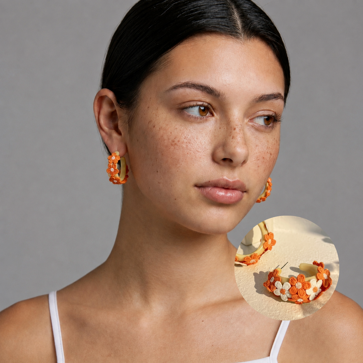 Image of Woman wearing Marigold Yellow embroidered daisy hoop earrings, front view looking away, studio background