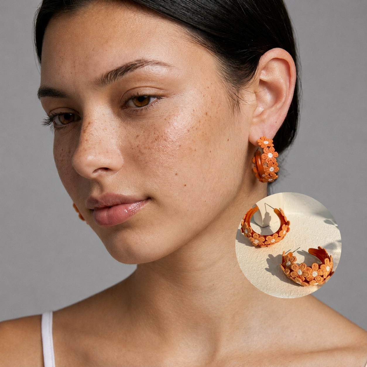 Image of Close-up side view of woman wearing Burnt Orange embroidered daisy hoop earrings, studio background