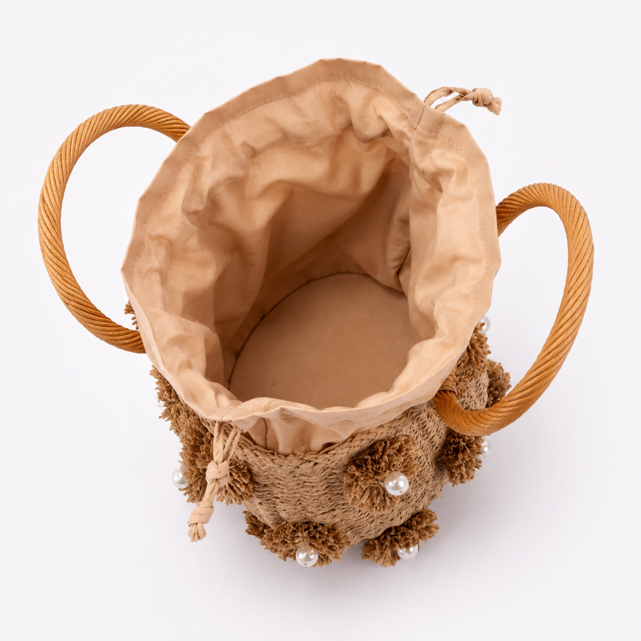 Image of A brown textured fabric drawstring bag with twisted rope handles and small pearl embellishments, shown from a top-down view on a white background.