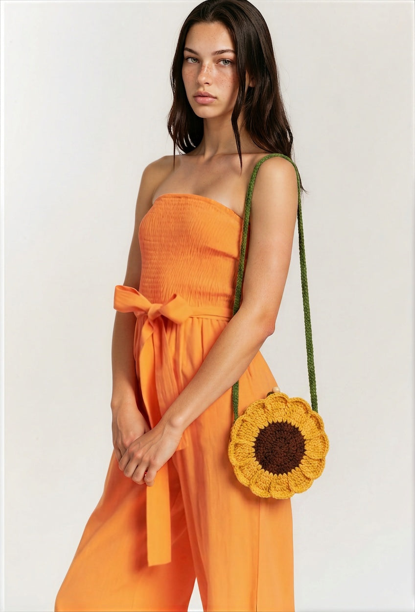 Image of Fall festival crocheted sunflower shoulder bag with a green strap worn by a model