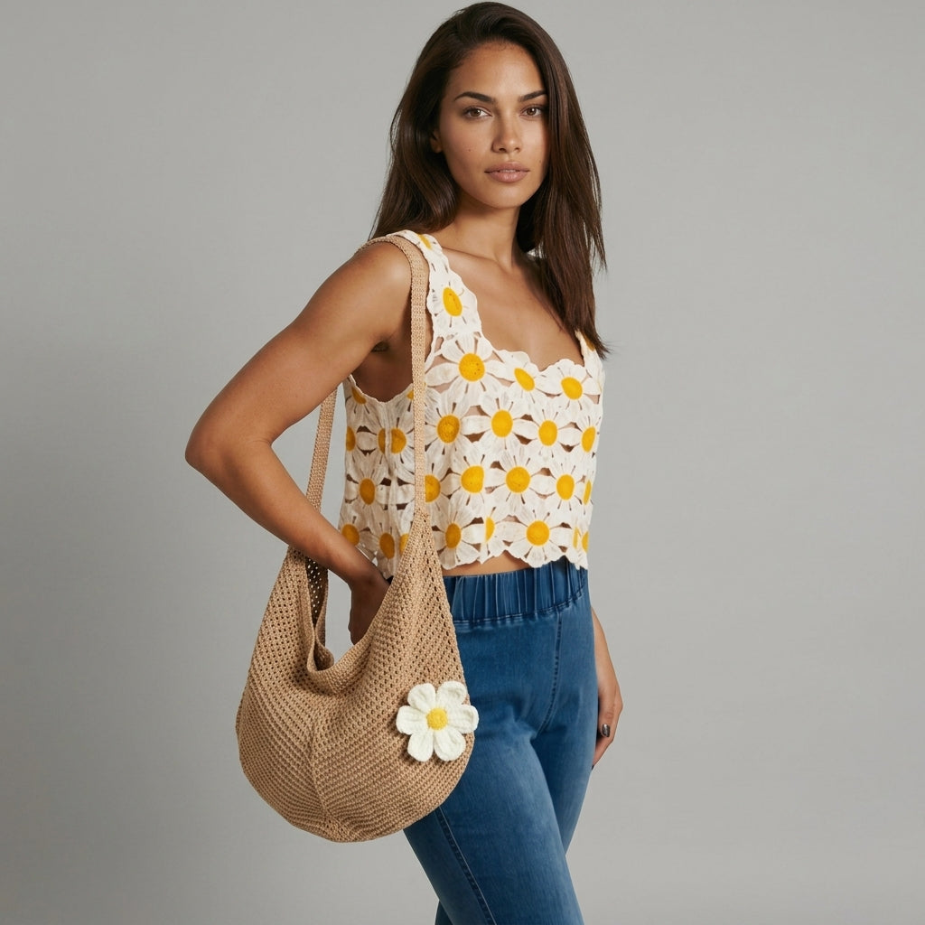 Image of Woman wearing a camel boho crochet bag with a dimensional daisy patch, slouchy hobo silhouette, floral top and jeans