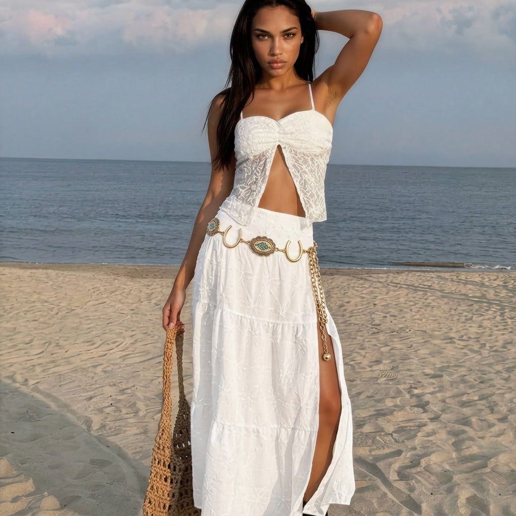 Image of Woman styling a vintage western belt with turquoise concho and horseshoe details over a flowing white beach dress at sunset