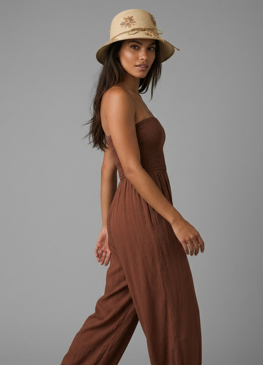 Image of A woman wearing Raffia Bucket hat with floral embroidery, photographed against a solid gray studio background.