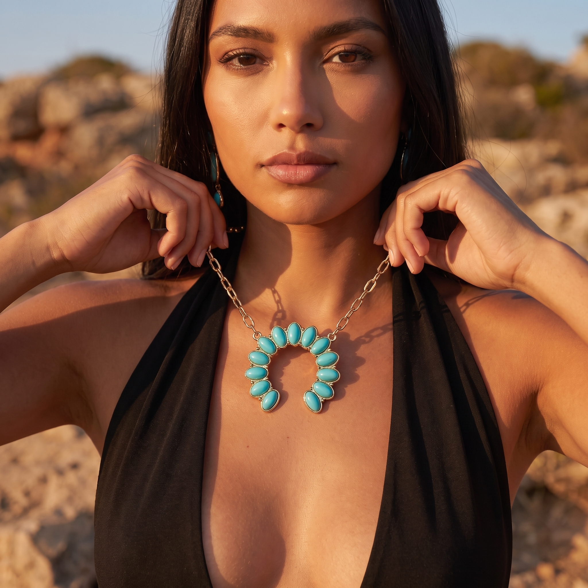 Image of A woman wearing a gold and turquoise crescent-shaped necklace with turquoise-colored stone beads, posing outdoors against a rocky, sunlit background.